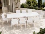 a white table and chairs on a patio by the water