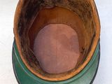 un pot marron et vert posé sur une table blanche