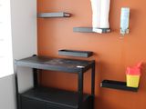 un bureau avec une étagère et une chaise dans un coin