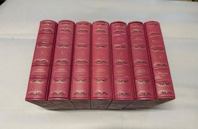 un lot de six livres rouges posés sur une table