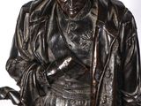 a bronze statue of a man holding a gun
