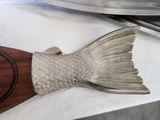 a fish shaped object sitting on a counter next to a pan