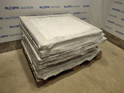 une pile de matelas posée sur une palette dans une pièce