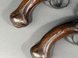 a pair of antique pistols on display on a gray surface