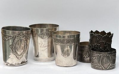 Plusieurs coupes et tasses en argent sont alignées sur une surface blanche