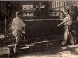 deux hommes travaillant sur une machine dans une usine, dont l'une est en marche