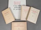 four books are sitting on a table next to a bag