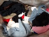 a pile of clothes in a basket on a bed