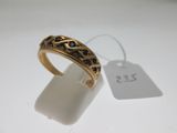 a close up of a gold ring with black stones on it