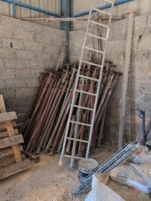 a ladder leaning against a wall next to a pile of wood