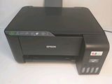 a black printer sitting on top of a table next to a white wall