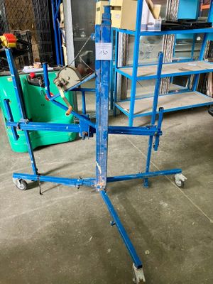 une plate-forme de travail bleue dans un entrepôt, à côté d'un conteneur vert