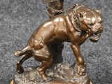 bronze statue of a dog with a basket on its head