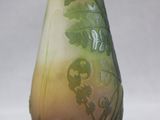 a glass vase with a green and yellow design on it