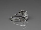 a close up of a silver ring with diamonds on a reflective surface