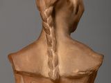 sculpture of a woman ' s head with braids on a table