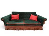 a green couch with red pillows on top of it