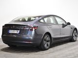 the back of a silver tesla model s parked on a checkered floor