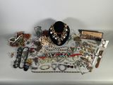 de nombreux bijoux posés sur une table blanche