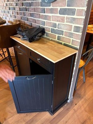 un homme qui ouvre une petite armoire dans un coin d'une pièce
