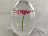 a glass vase with a flower inside of it