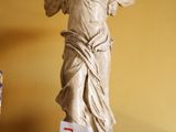 une statue d'ange posée sur un socle dans une pièce
