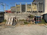 un tas de palettes à côté d'un bâtiment entouré d'une clôture