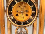 a gold clock with roman numerals on the face