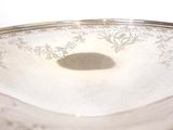 a silver plate with a bird on it on a table