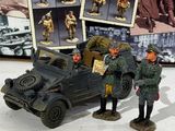 two toy soldiers standing next to a toy car