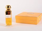 l'image d'un flacon de parfum posé à côté d'une boîte