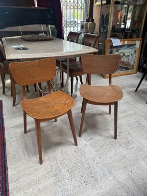 several chairs and a table in a room with a lot of furniture