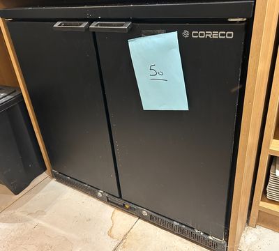 une photo d'un réfrigérateur noir sur lequel est collé un autocollant bleu