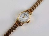une image d'un gros plan d'une montre-bracelet sur une surface blanche
