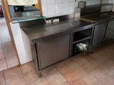 a stainless steel counter top in a kitchen with tile flooring