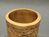 une tasse en bois ornée de sculptures, posée sur une table