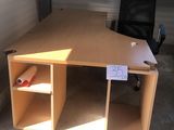 un bureau en bois avec une chaise noire dans un coin