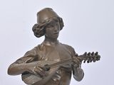 bronze statue of a woman playing a guitar on a marble base