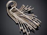 a silver broochle with diamonds on a black background
