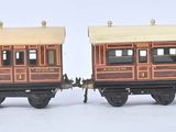 deux petits trains miniatures posés côte à côte sur une surface blanche