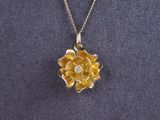 a close up of a necklace with a flower on it