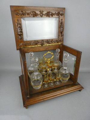 a wooden display case with a glass set inside of it