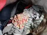 a pile of clothes in a basket on a bed