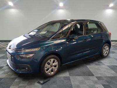 La Citroën bleue est garée dans le garage, sur un sol à damier.