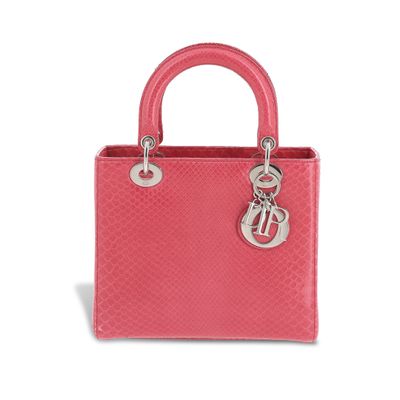 un sac à main rose muni d'une poignée en métal, sur fond blanc