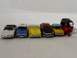several toy cars are lined up next to each other on a white surface