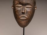 a wooden mask with a crown on top of it