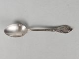 silver spoon on a white surface with a silver spoon in the middle of it