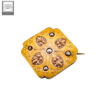 une image représentant une broche en or et perles ornée d'une étoile