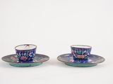 deux tasses et soucoupes empilées l'une sur l'autre sur une surface blanche